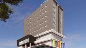 A modern hotel with a multi-story structure, a prominent 'amaris' sign, and a ground-level entrance with a green awning. - Amaris Hotel Manado (Wenang)
