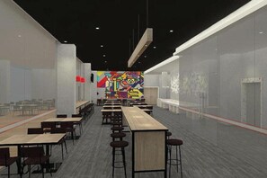 A modern interior with long tables and chairs, a colorful mural, and a glass partition. - Amaris Hotel Manado (Wenang)