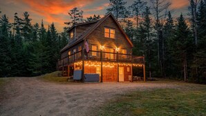 A log cabin with a porch, a flag, and a garage.