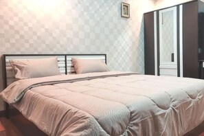 A neatly made bed with a headboard, a window with a view, and a door with a mirror. - 24 Hostel Donmuang (Bangkok)