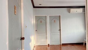 A hallway with two white doors, a wooden floor, and a ceiling with a recessed light fixture. - 24 Hostel Donmuang (Bangkok)