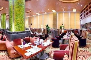 A spacious hotel lobby with multiple seating areas, including a bar and a dining area. - USUM International Hotel (Chongqing)