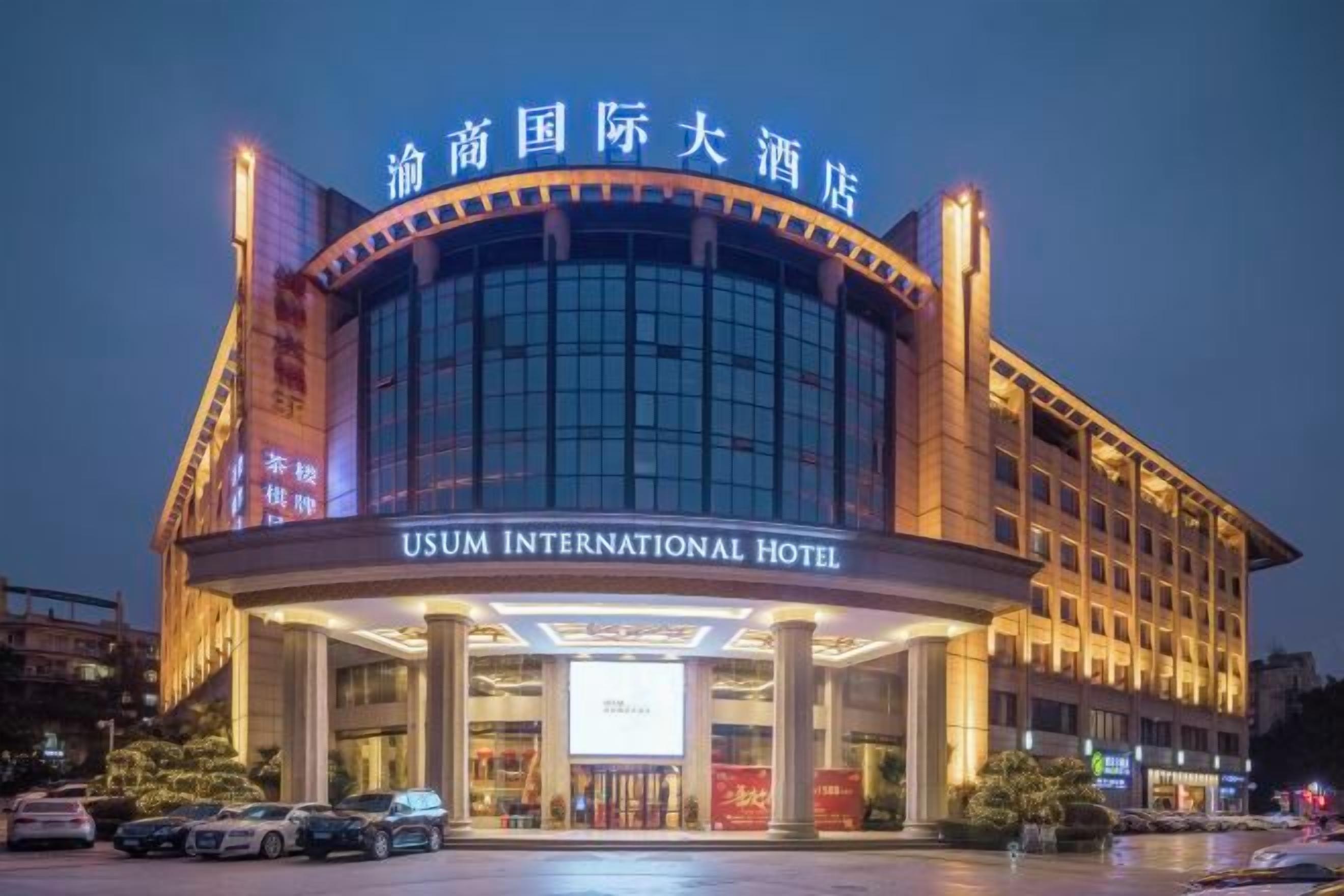 Un hotel con fachada moderna, amplias ventanas de vidrio y señalización destacada que indica que se trata del HOTEL USUM INTERNATIONAL.