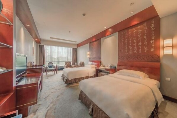 A hotel room with two beds, a desk, a TV, and a large window with curtains. - USUM International Hotel (Chongqing)