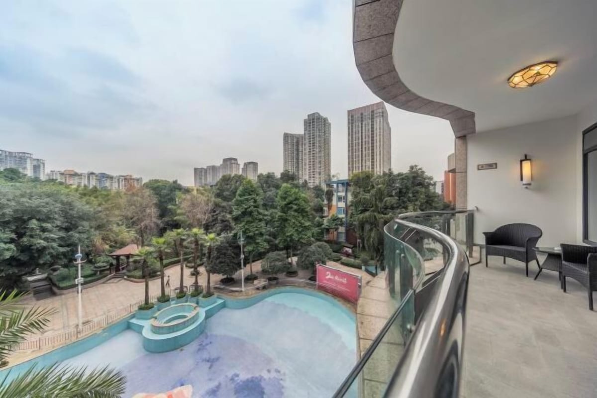 Un balcon donnant sur une piscine, avec une chaise et une table.