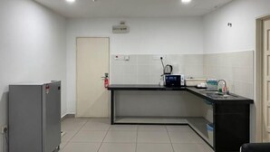 Uma cozinha compacta com geladeira, pia e bancada.
