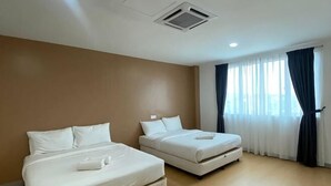 Quarto de hotel com duas camas, uma janela com cortinas e um respiradouro no teto.
