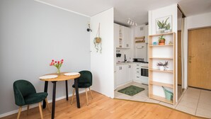 Une cuisine moderne avec des armoires blanches, un plan de travail en bois et un tapis vert.