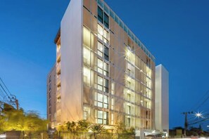 Ett hotell med flera våningar och modern design, med en framträdande vertikal struktur på höger sida.