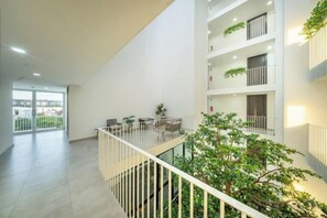 Ein modernes Interieur mit Balkon, Zimmerpflanzen und Blick ins Freie.
