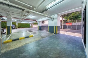 A multi-level parking garage with concrete floors and yellow and black striped barriers. - SHIN Patara Living Hotel (Bangkok)