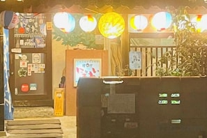 Entrada de hotel con mostrador de recepción, un cartel y una puerta de seguridad.