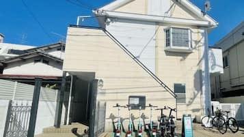 A building with a sloped roof, a bicycle parked outside, and a signboard.