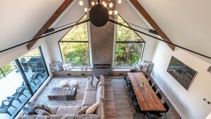 Un loft spacieux doté d’une grande fenêtre, d’une table à manger en bois, d’un canapé et d’une cheminée.