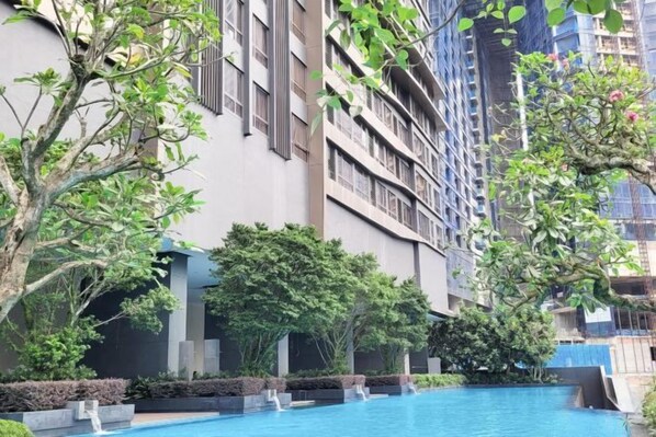 Ein Pool, umgeben von Grünflächen und modernen Gebäuden.