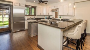 A modern kitchen with a large island, stainless steel appliances, and bar stools. - New! Hot Tub, Town Center, Western Luxe Delight! (Big Sky)