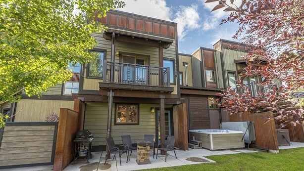A two-story house with a balcony, outdoor seating, and a hot tub. - New! Hot Tub, Town Center, Western Luxe Delight! (Big Sky)