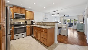 Una cocina moderna con armarios de madera, electrodomésticos de acero inoxidable y una isla grande.