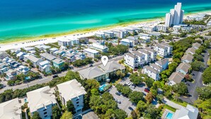 An aerial view of a coastal residential area with beachfront properties, a swimming pool, and a clear view of the ocean. - Seagrove Beach Retreat | Steps to the Sand (Seagrove Beach)