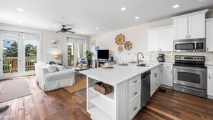 A modern kitchen with white cabinetry, stainless steel appliances, and a central island.