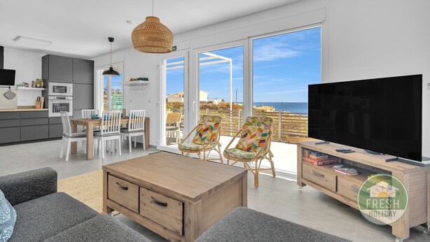 A modern living room with a large TV, dining area, and a view of the sea. - Family cottage in Benajarafe w pool and sea view (Vélez-Málaga)