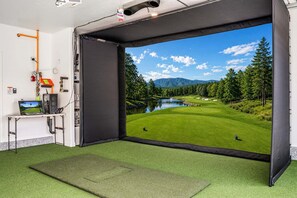 Une pièce dotée d’une grande fenêtre donnant sur un terrain de golf, d’un bureau avec un ordinateur et de divers équipements électroniques.