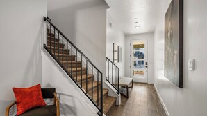 A staircase with a wooden handrail and carpeted steps, leading to a door with a view of a house outside. - 1626, Private Swim Spa, Hot tub, Resort access (Washington)