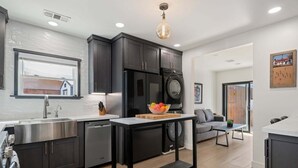 A modern kitchen with dark cabinetry, stainless steel appliances, and a central island.