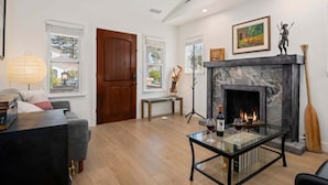 A living room with a fireplace, a sofa, a coffee table, and a lamp.