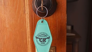 A wooden door with a brass doorbell and a keychain. - Aspen Room Serene Retreat at Columbine (Silverton)