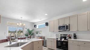 Una cocina moderna con una isla central, electrodomésticos de acero inoxidable y armarios de tonos claros.