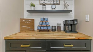 A kitchen counter with a coffee maker, a clock, and a welcome sign. - Family Friendly Retreat near Clearwater Beach. (Safety Harbor)