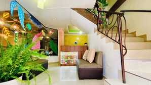 Een modern interieur met een trap, een bank en potplanten.