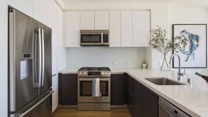 A modern kitchen with stainless steel appliances, a dishwasher, and a sink. - Visit LA in Ultra Luxury with Breathtaking Views (Beverly Hills)