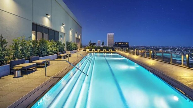 A rooftop pool with a city view at night. - Visit LA in Ultra Luxury with Breathtaking Views (Beverly Hills)