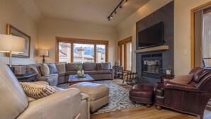 A spacious living room with a fireplace, large windows, and a comfortable seating area. - Experience comfort in this 2-bedroom condo at Purgatory Village, Durango. (Durango)