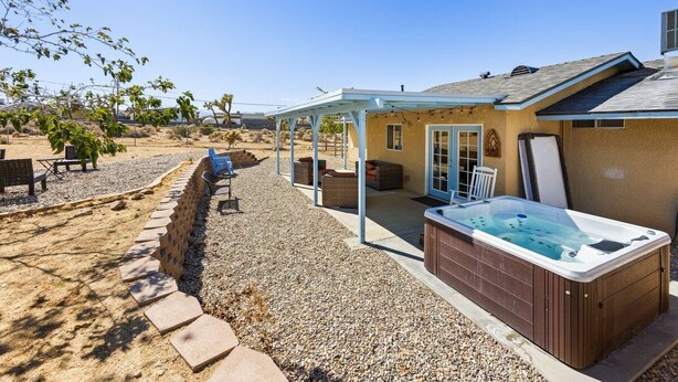 A residential property with a covered patio, a hot tub, and outdoor seating. - Starlight Ranch with Hot tub, Fire pit & BBQ! (Joshua Tree)