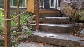 Un escalier en bois mène à une maison dont le toit est en métal.