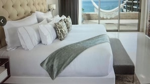 A hotel room with a large bed, a view of the sea, and a hammock by the window. -  Available Oct.22-28th Luxury at its finest!!! 1-Bedroom, 1300 sq ft Condo, (Cabo San Lucas)