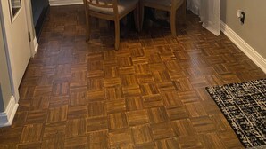 Ein Essbereich mit einem runden Tisch, vier Stühlen, einem Deckenventilator und einem großen Spiegel über dem Tisch.