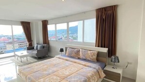 Una camera da letto moderna con un letto grande, un divano e un comodino.