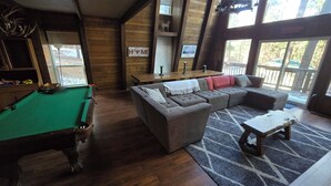 A cozy room with a pool table, a sectional sofa, and a bar area. - The Cub House: Mountain Home w/ Hot Tub, Pool Table, 5 bed/4ba, Fireplace, Woods (Ruidoso)