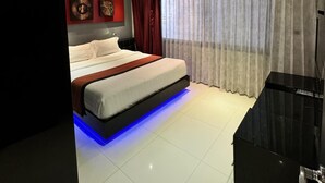 A modern bedroom with a large bed, a flat-screen TV, and a ceiling with recessed lighting and blue LED accents. - L08 Penthouse Suite, Modern Condo On Bangla Road (Patong)