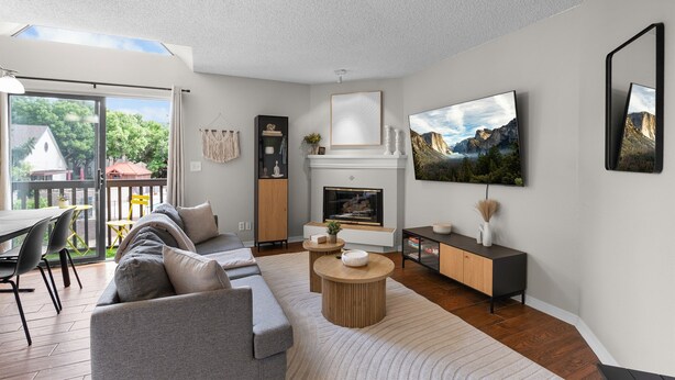 Een moderne woonkamer met een bank, salontafel, open haard en kunstwerken aan de muur.