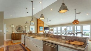 A spacious kitchen with granite countertops, stainless steel appliances, and pendant lighting. - Bay Breeze - Waterfront with Boat Dock, Helipad! (Panacea)