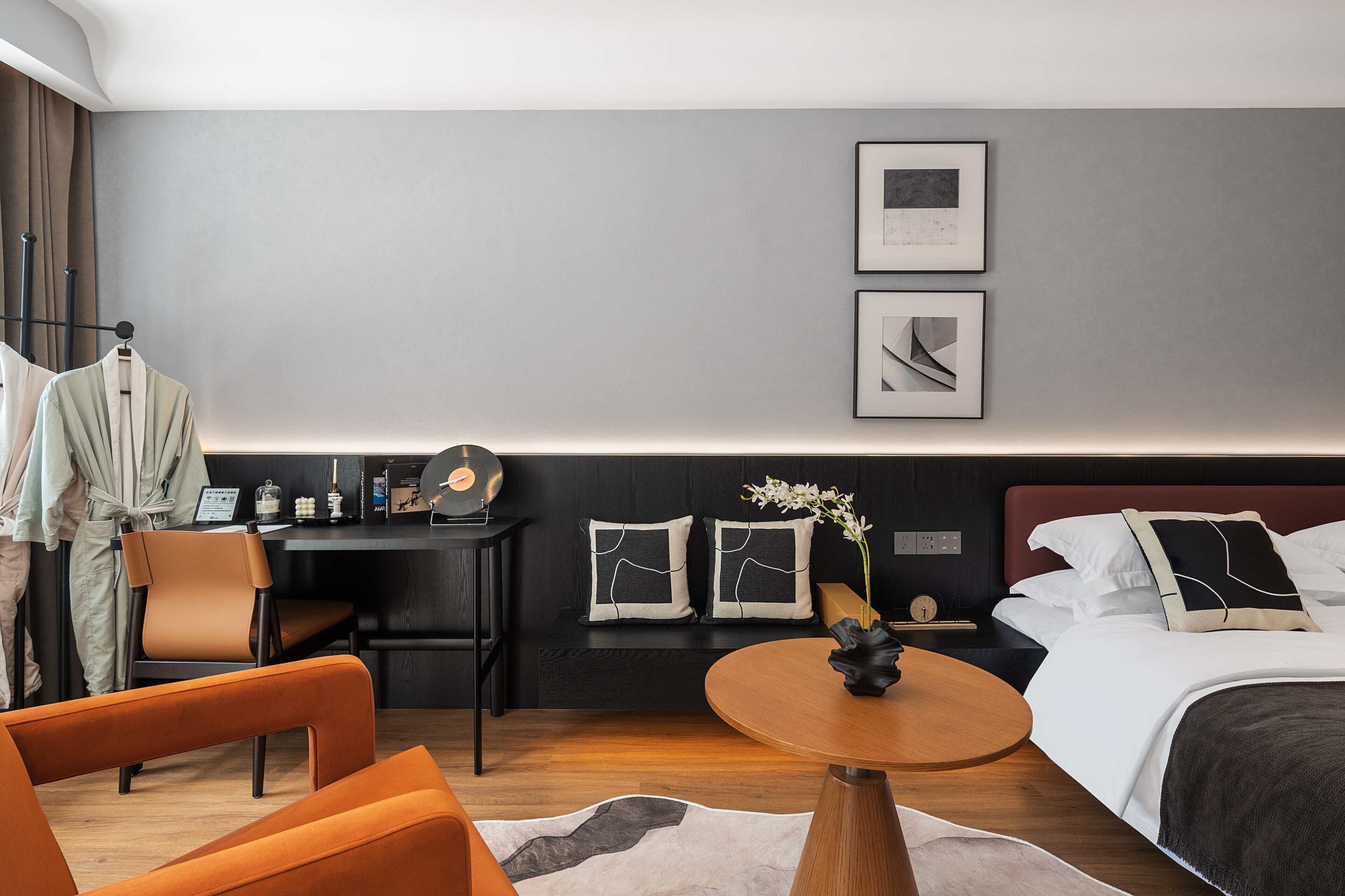 Una habitación de hotel moderna con cama, escritorio, silla y una mesa redonda.