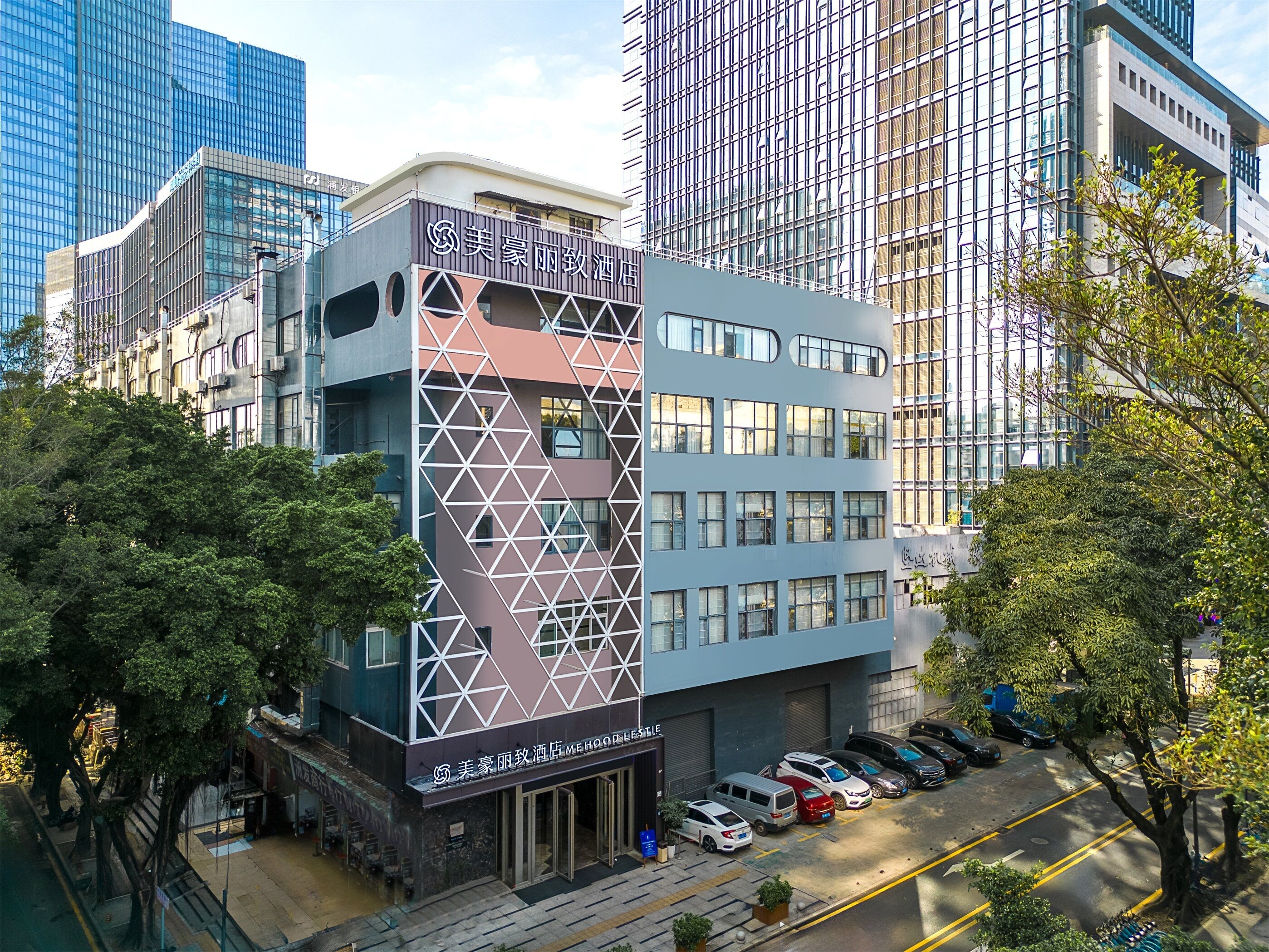 A modern hotel with a geometric facade, surrounded by high-rise buildings.