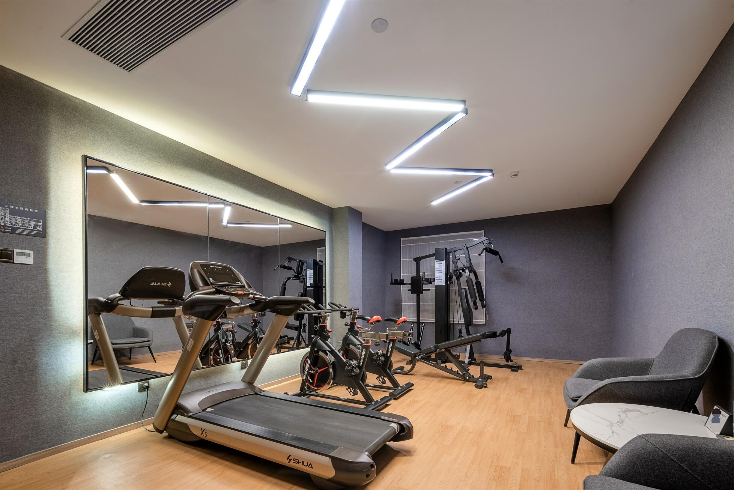 A modern gym with treadmills, stationary bikes, and weight machines.