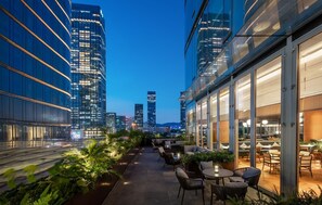 A rooftop terrace with outdoor seating, surrounded by high-rise buildings, offering a view of the city skyline. - IntercityHotel Futian Zhongzhou Bay (Shenzhen)