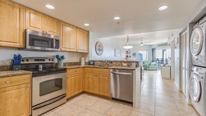 A kitchen with wooden cabinets, stainless steel appliances, and a dishwasher. - Vitamin SEA Condo 7️⃣2️⃣7️⃣2️⃣5️⃣1️⃣8️⃣6️⃣5️⃣9️⃣ (Treasure Island)